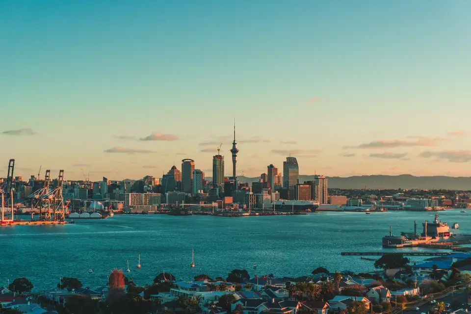 The Auckland skyline and harbor under a warm low sun in New Zealand