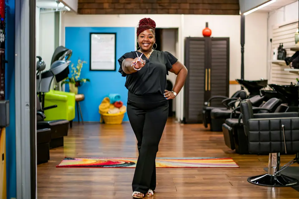 Woman in salon gives peace sign towards camera